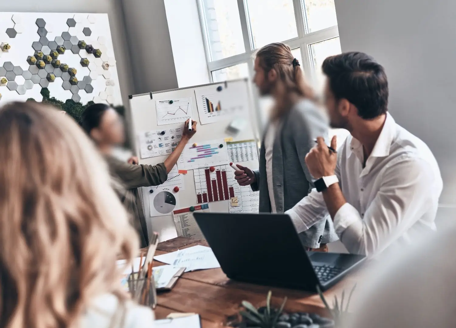 a group of people at a conference table in front of a whiteboard
