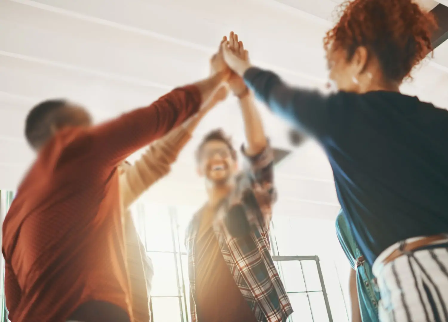 a group of people in an office giving each other high fives