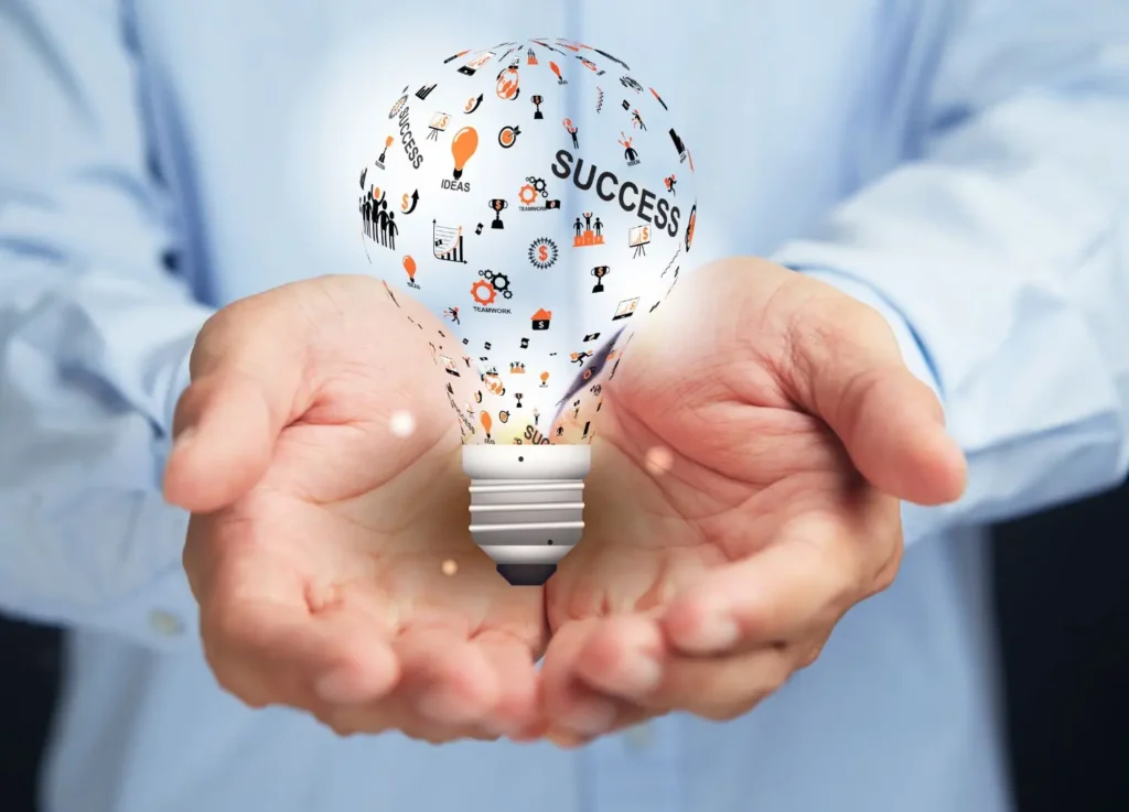 a person holding a light bulb with icons coming out of it