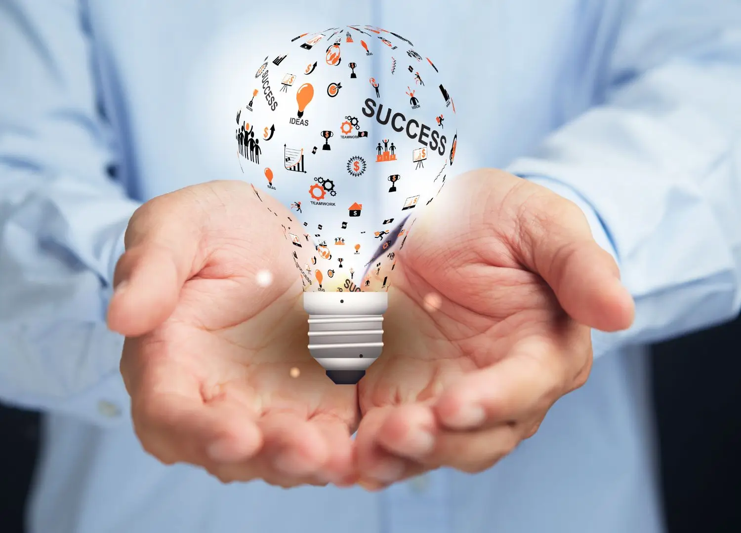 a person holding a light bulb with icons coming out of it